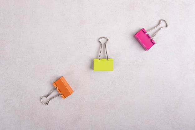 Free photo colorful paper clips on white background.