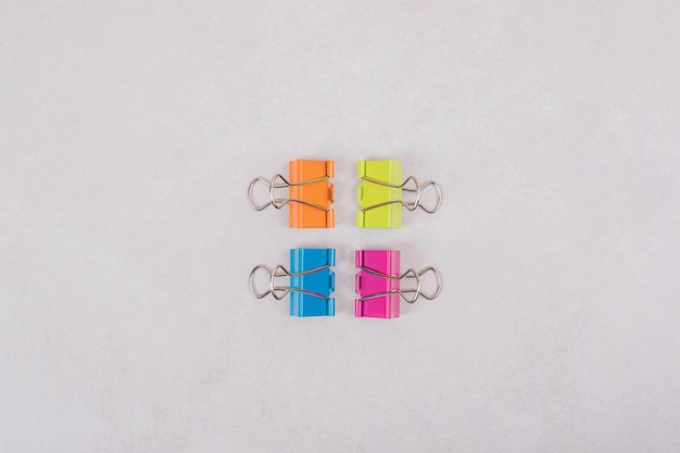 Free photo colorful paper clips on white background.