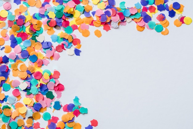 Colorful paper confettis on a white surface