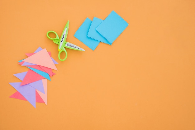 Цветная бумага и ножницы на цветном фоне