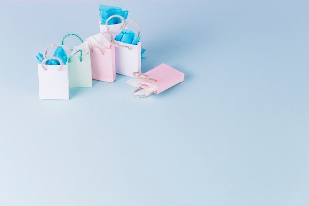 Colorful paper shopping bags on blue surface