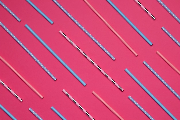 Colorful paper straws on pink background