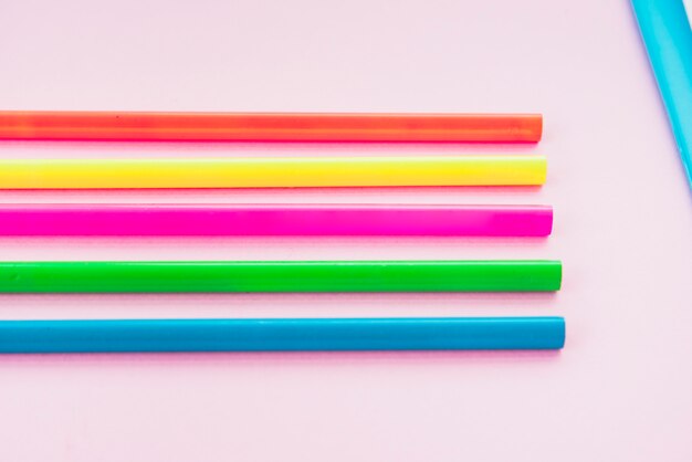 Colorful pencil arranged in row on plain backdrop