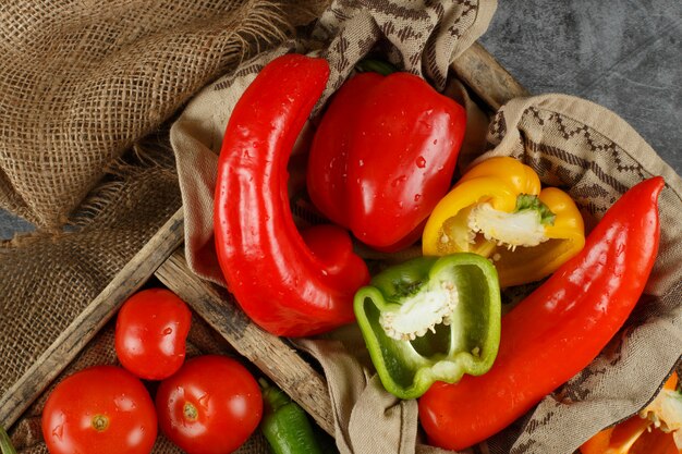 Colorful peppers in a rustic tray. Top view.