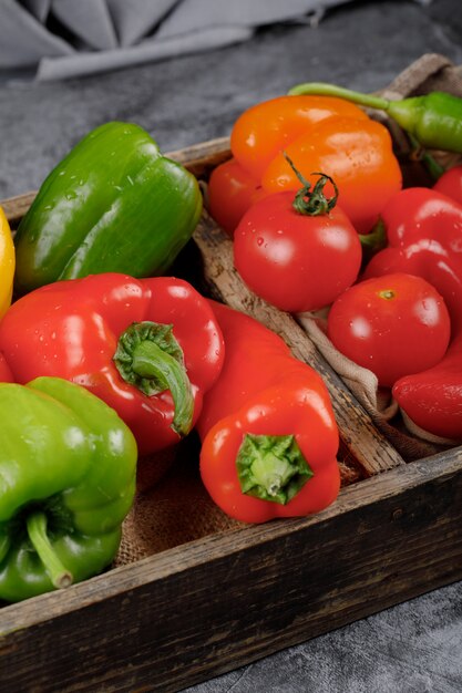 Colorful peppers and tomatoes with water drops on them.