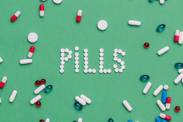 Colorful pills on green background
