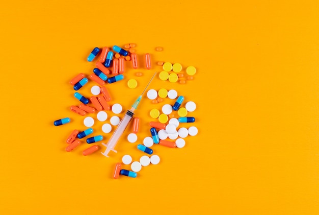 Colorful pills and needle