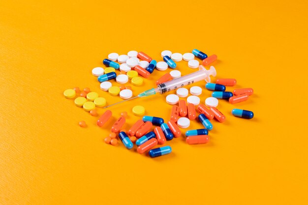 Colorful pills and needle