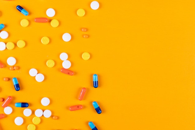 Colorful pills on a orange surface