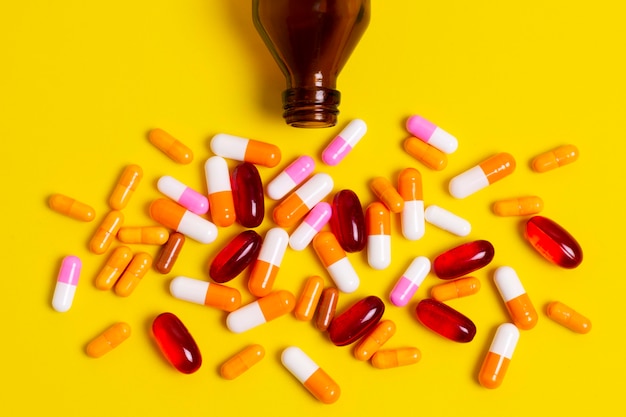 Free photo colorful pills on yellow background