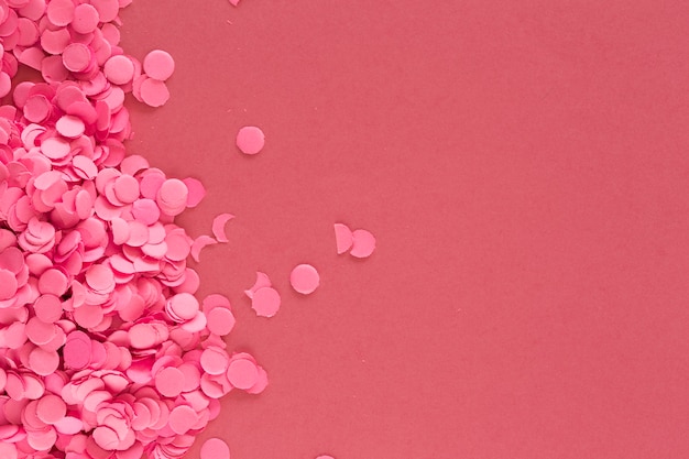 Free photo colorful pink confetti pieces on pink