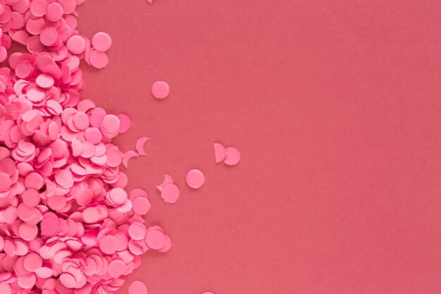 Colorful pink confetti pieces on pink