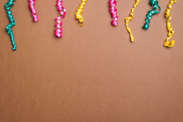 Colorful pink; green and yellow streamers on brown background