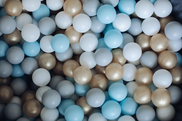 Colorful plastic balls from above Top view of colorful plastic balls in a pile heap White golden blue gray colors