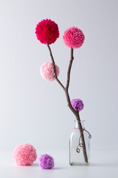 Colorful pom poms in bottle arrangement