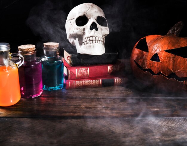 Colorful potions with pumpkin on table