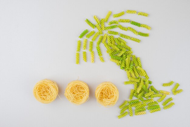 Colorful raw macaroni as a palm on white surface