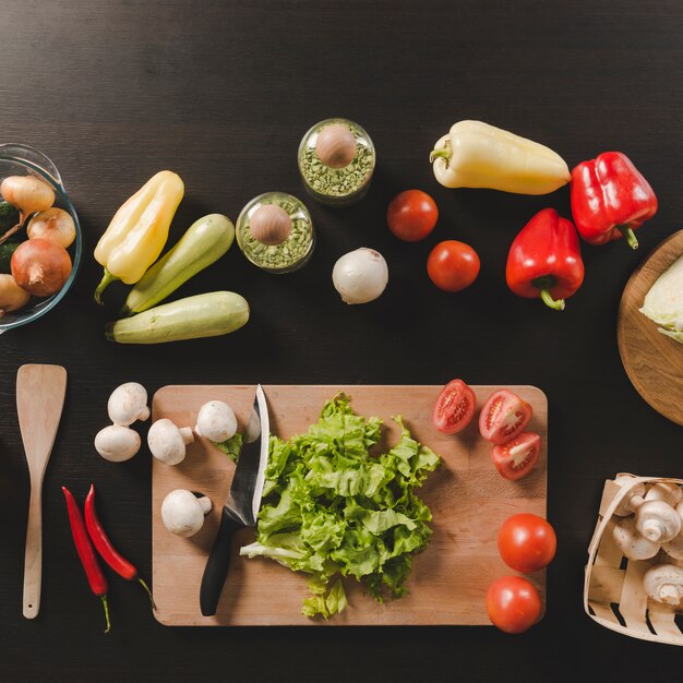 Colorful raw vegetables on black kitchen counter