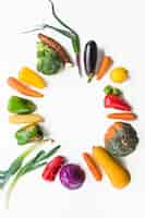 Free photo colorful raw vegetables forming frame on white surface