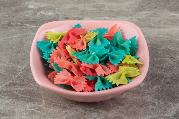 Colorful ribbon pasta in pink bowl