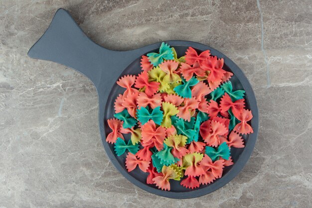 Colorful ribbon pasta on wooden board