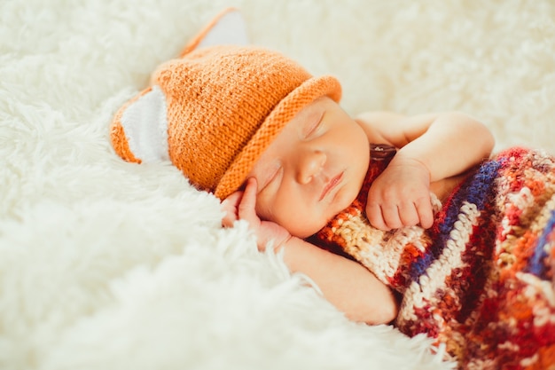 Colorful scarf covers little baby sleeping on the fluffy pillow 