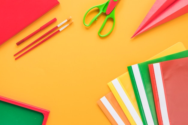 Colorful school supplies on yellow background