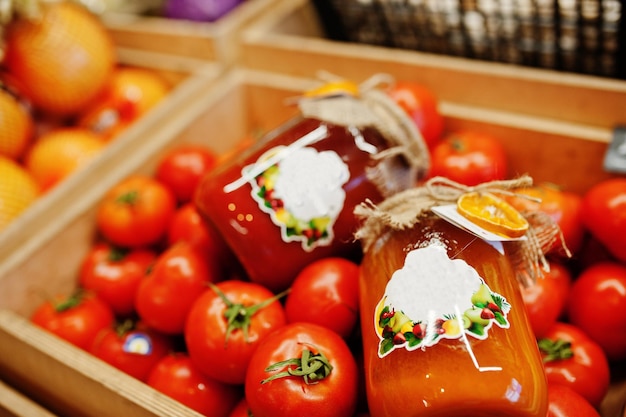 スーパーマーケットや食料品店の棚に缶詰のオムメイドと手作りのトマトジュースが入ったカラフルな光沢のある新鮮な野菜トマト