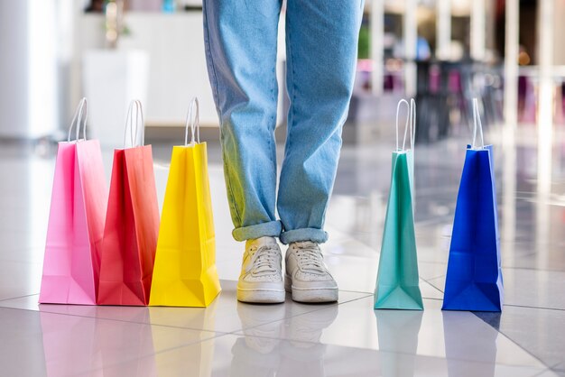 Colorful shopping bags close to legs