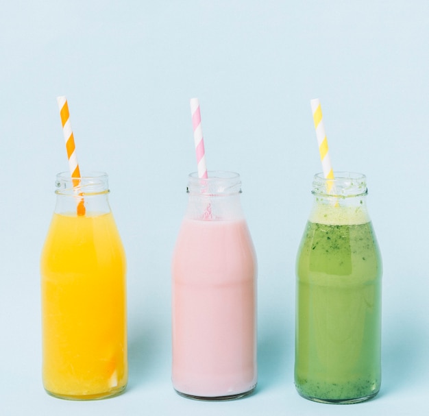 Colorful smoothie bottles with blue background