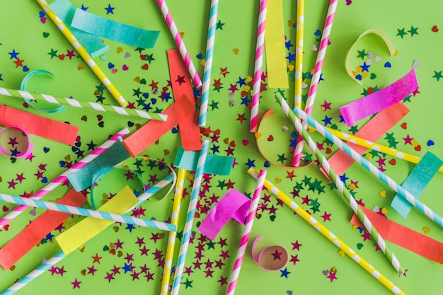 Free photo colorful sticks with carnival decoration on a green table