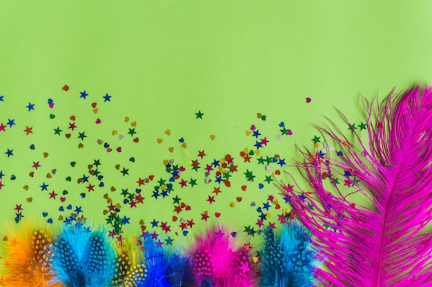 Colorful sticks with confetti underneath on a green table