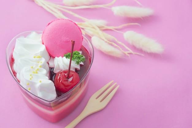 Colorful strawberry cake and macaron on pink background