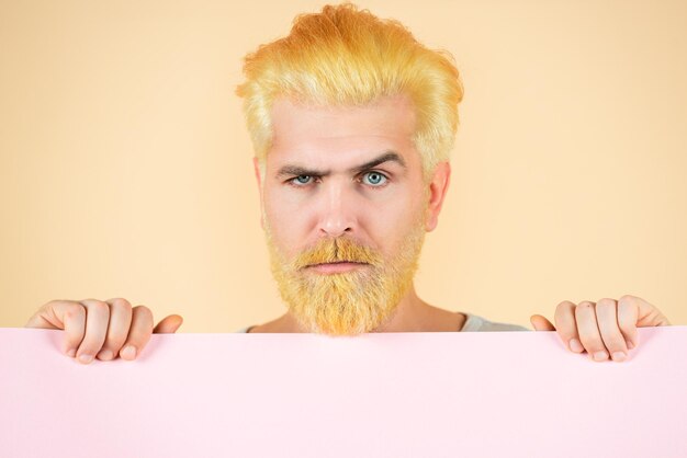 Colorful studio portrait of serious man close up on isolated yellow background