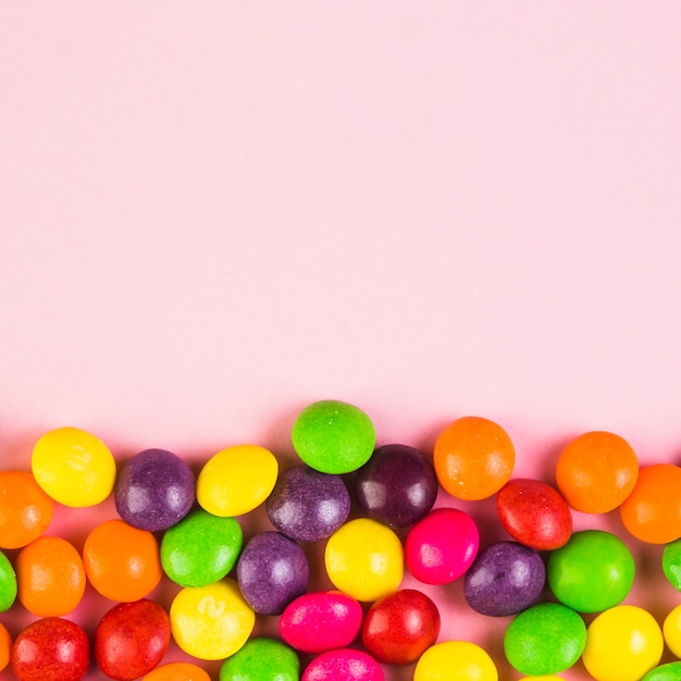 Colorful sweet candies on pink background