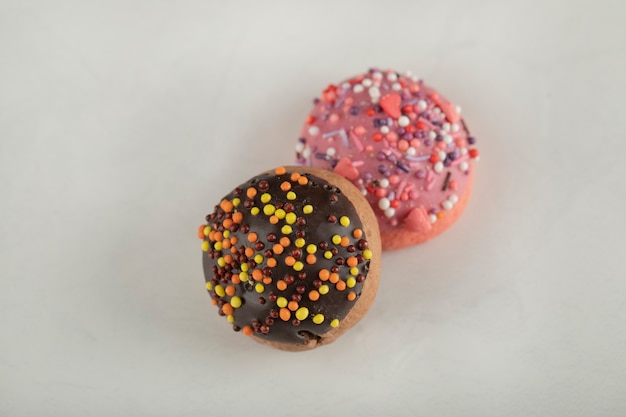 Colorful sweet chocolate small doughnuts with sprinkles .