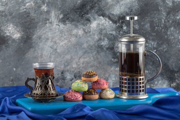 Colorful sweet doughnuts with a cup of tea. 