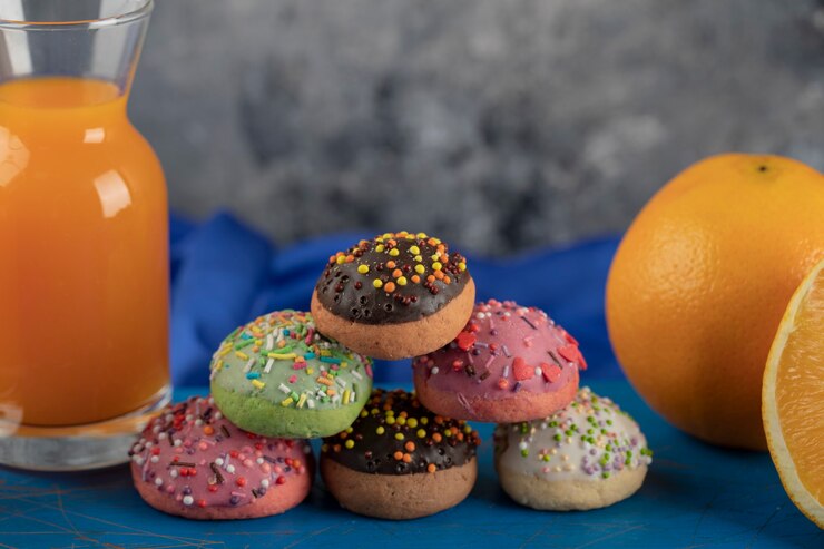 Free Photo colorful sweet doughnuts with a glass jar of juice . 