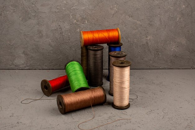 Colorful threads for sewing on a grey background