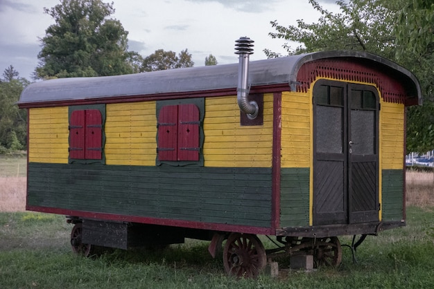 Colorful trailer in the middle of a field under the cloudy sky