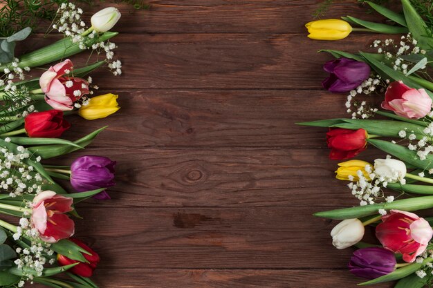 Colorful tulips and baby's breath flower on wooden textured table