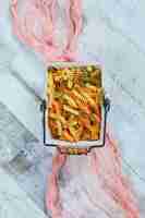 Free photo colorful uncooked pasta with pink tablecloth.