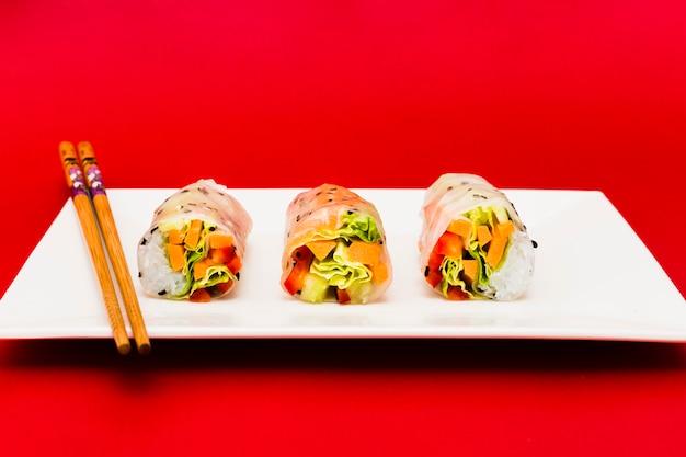 무료 사진 흰 접시 위에 춘권과 젓가락에 박제 다채로운 야채