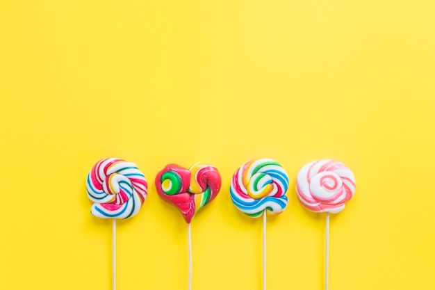 Colouful lollipops on yellow background