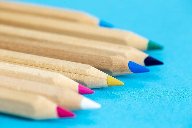 Colour pencils isolated on blue background close up