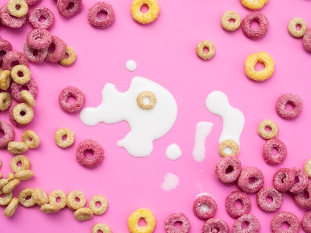 Coloured fruity loops and milk on pink background