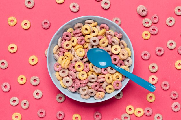 Colourful cereal in blue bowl with spoon top view