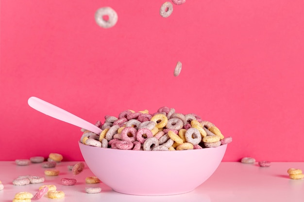 Colourful cereal in pink bowl with spoon