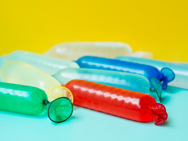 Colourful condoms filled with water on blue background