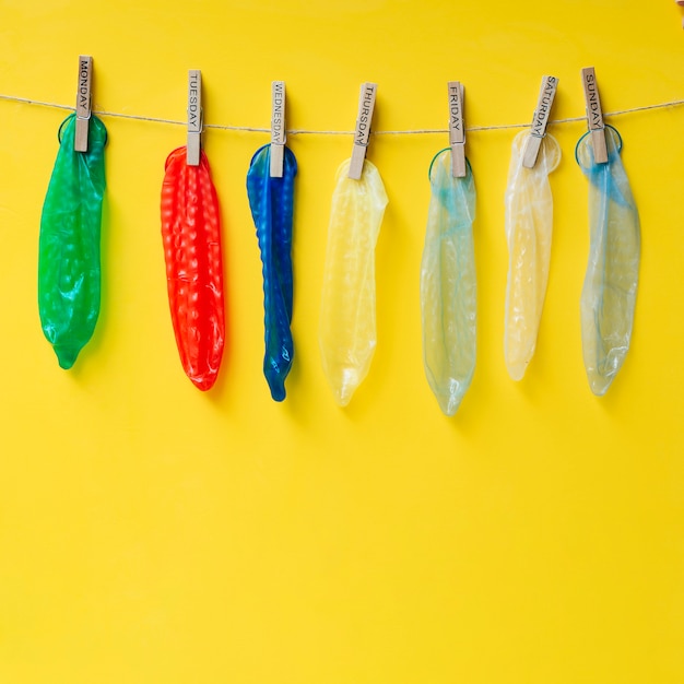 Разноцветные презервативы висят на веревках